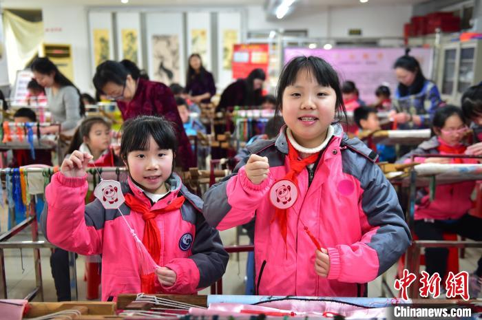 圖為小學(xué)生展示繡制好的2022年北京冬奧會(huì)吉祥物“冰墩墩”形象?！∮髟屏?攝