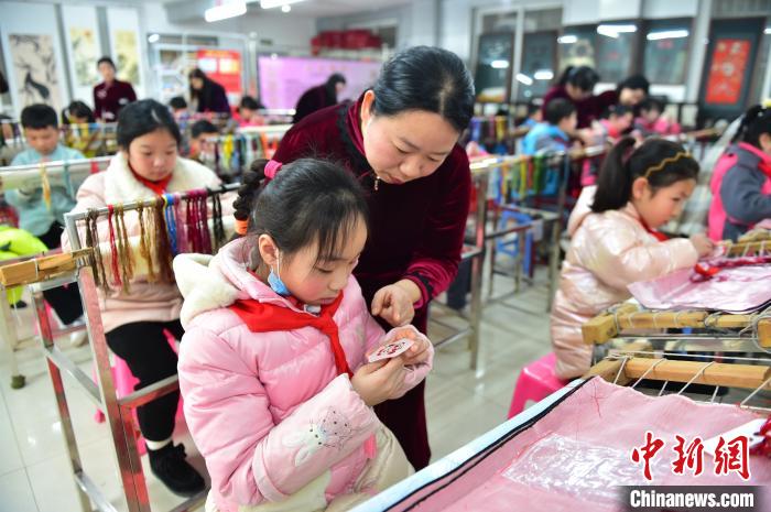 江西省級(jí)非遺豫章繡傳承人手把手指導(dǎo)小學(xué)生繡制2022年北京冬奧會(huì)吉祥物“冰墩墩”形象?！∮髟屏?攝