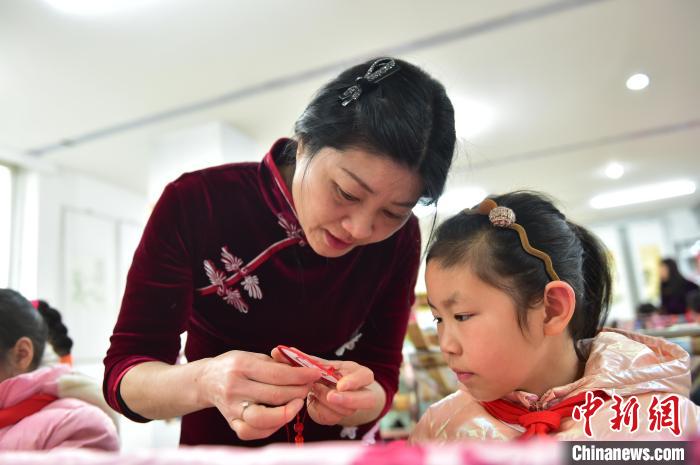 江西省級(jí)非遺豫章繡傳承人手把手指導(dǎo)小學(xué)生繡制2022年北京冬奧會(huì)吉祥物“冰墩墩”形象?！∮髟屏?攝