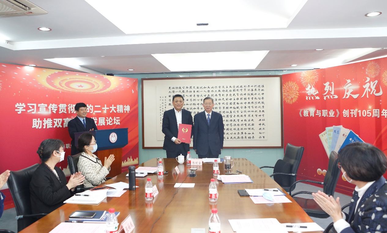 郝明金為《教育與職業(yè)》雜志編委代表陳曉明頒發(fā)聘書。中華職教社供圖