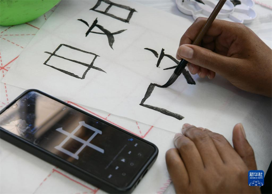 4月18日，肯尼亞學(xué)生在內(nèi)羅畢大學(xué)孔子學(xué)院舉辦的活動上寫毛筆字。肯尼亞內(nèi)羅畢大學(xué)孔子學(xué)院18日舉辦“中文，增進(jìn)文明對話”主題活動，慶祝即將到來的第14個(gè)聯(lián)合國中文日?？夏醽唽W(xué)生參與互動，進(jìn)行書法、剪紙、唱中文歌等活動。新華社記者 韓旭 攝