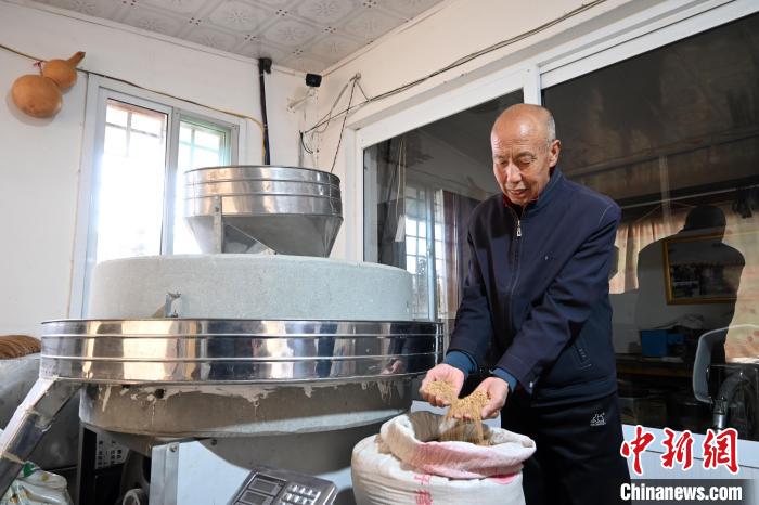 李家莊村民谷文朝重拾父輩的手藝，做起石磨面粉的營生?！〉杂鸺?攝