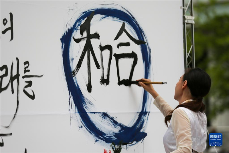5月30日，在韓國首爾舉辦的“中日韓合作之日”慶?；顒又?，表演者進行中日韓精神——2023年度漢字“和合”書法表演。新華社記者 王益亮 攝