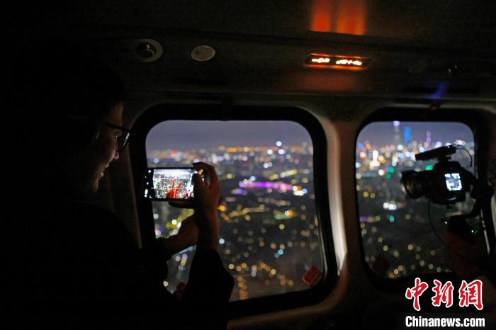 6月3日晚，游客乘坐上海新空直升機(jī)有限公司直升機(jī)開啟鳥瞰黃浦江空中圓夢之旅，并用手機(jī)拍攝城市夜景。　殷立勤 攝
