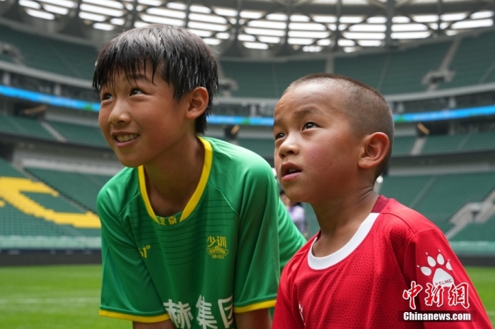 圖為北京國安小球員陳小北和7歲的俄金仁增在一起觀看場內(nèi)播放的紀(jì)錄片。<a target='_blank' href='/' _fcksavedurl='/'><p  align=