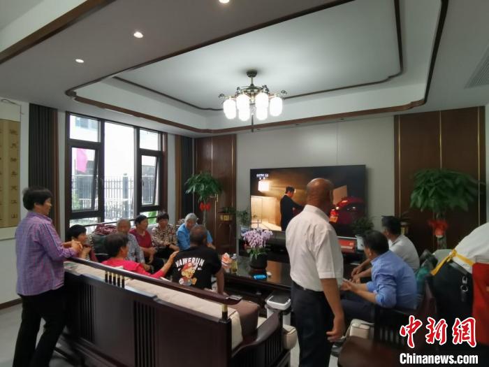 親友們集中在費(fèi)俊龍家中觀看返程的視頻?！＄娚?攝