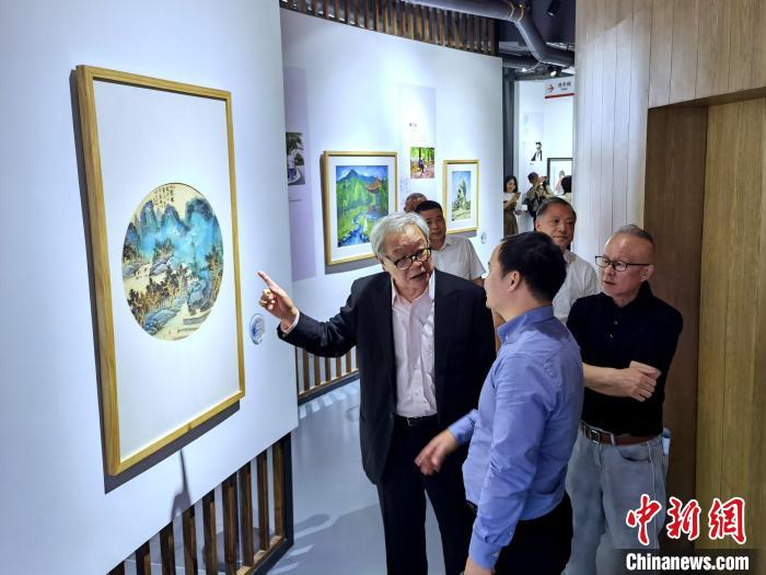 海峽兩岸藝術(shù)家畫展上，藝術(shù)家進(jìn)行藝術(shù)交流?！「毒窜?攝