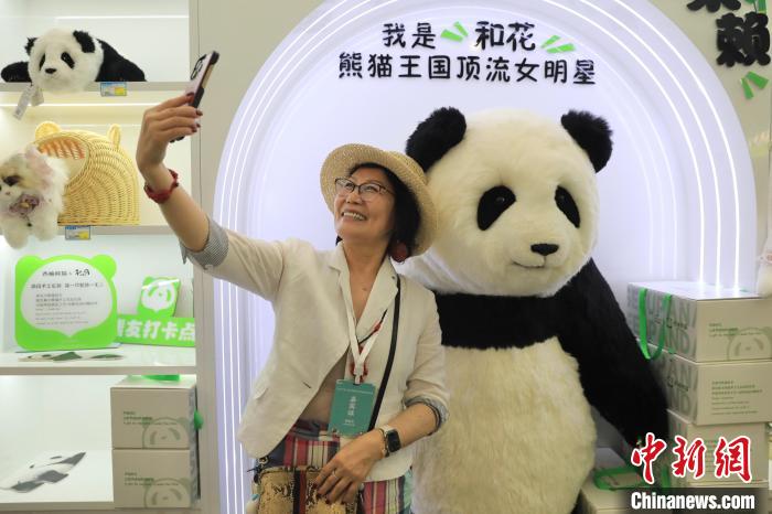 美國華視總裁楊蓮花與大熊貓文創(chuàng)產品合影。　王磊 攝