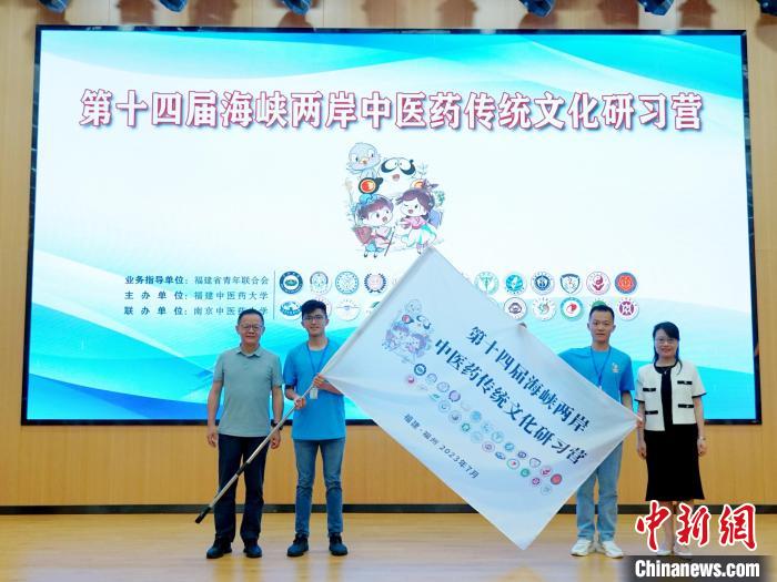 共青團(tuán)福建省委副書(shū)記吳雪(右一)、福建中醫(yī)藥大學(xué)黨委副書(shū)記林羽(左一)為兩岸學(xué)生代表頒授營(yíng)旗?！≡S燁婷 攝