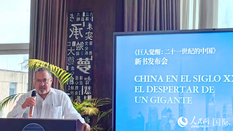 羅德里格斯博士現(xiàn)場介紹著作。吳志華攝
