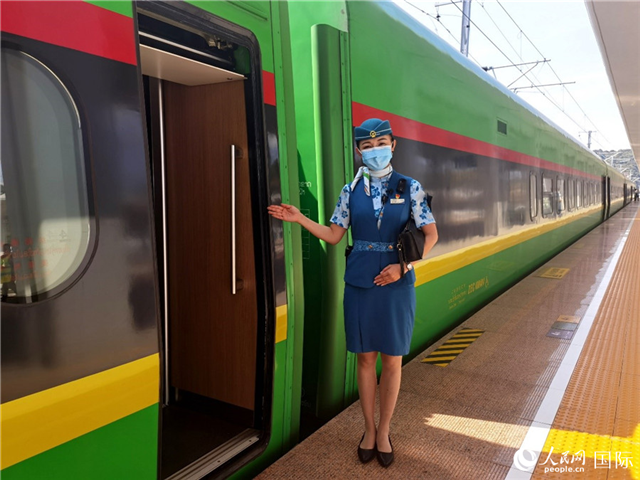 趙瑩靜站在“復(fù)興號”國際旅客列車車廂門口歡迎旅客上車。人民網(wǎng) 杜明明攝