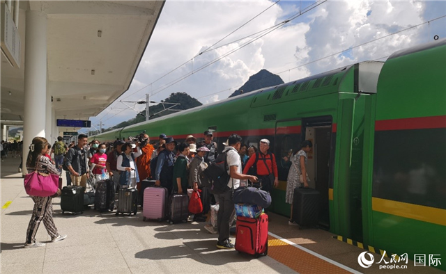 乘坐中老鐵路國際旅客列車的旅客在老撾瑯勃拉邦站排隊上車。人民網(wǎng)記者 杜明明攝