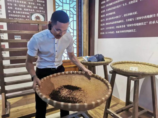 2023“一帶一路”媒體合作論壇聯(lián)合采訪團(tuán)團(tuán)員在非遺文化展示館體驗(yàn)中藥炮制技藝。（本報(bào)記者 黃超攝）