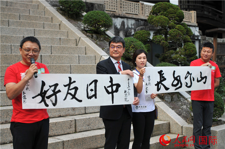 東京中國文化中心主任羅玉泉展示其為本次活動書寫的題詞“中日友好，山高水長”。人民網(wǎng) 蔣曉辰攝