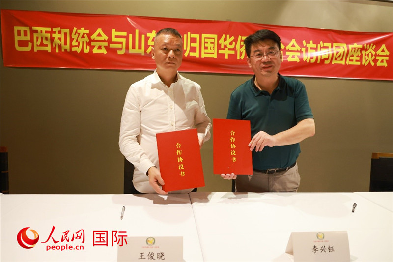 中國僑聯(lián)副主席、山東省僑聯(lián)主席李興鈺（右）與巴西和統(tǒng)會會長王俊曉簽署合作協(xié)議書。人民網(wǎng)記者 陳海琪攝