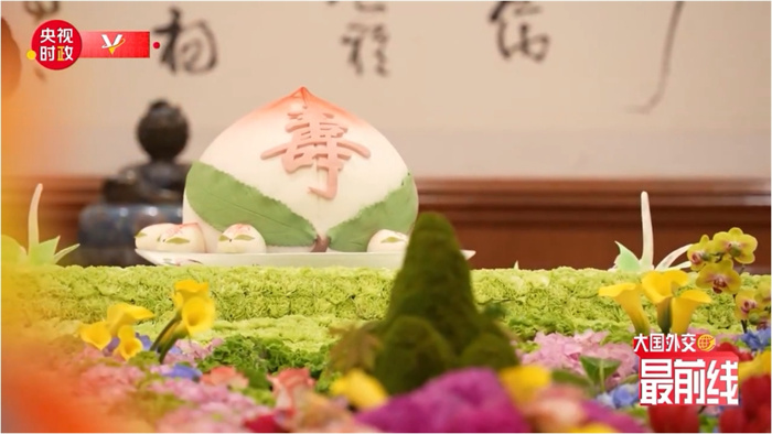 圖為今年7月基辛格訪華時(shí)午宴上的壽桃。來(lái)源：央視新聞截圖