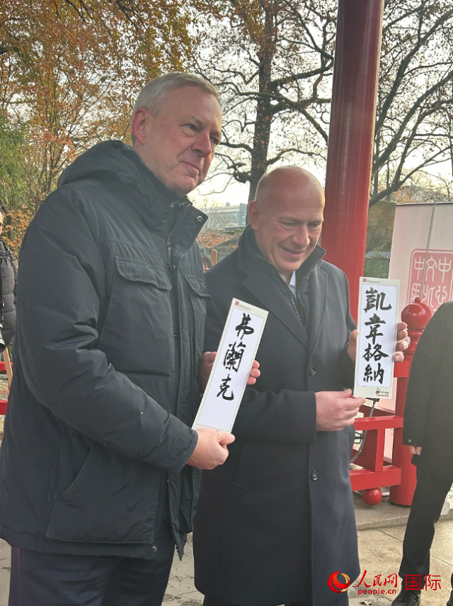 柏林市長韋格納（右）、動物園監(jiān)事會主席布魯克曼（左）手持中國文化中心工作人員現(xiàn)場手書的中文名字。人民網(wǎng)記者 徐馨攝