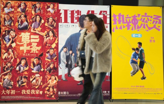 這是2月17日，在沈陽一家影院，觀眾從海報(bào)前經(jīng)過。新華社記者李鋼攝