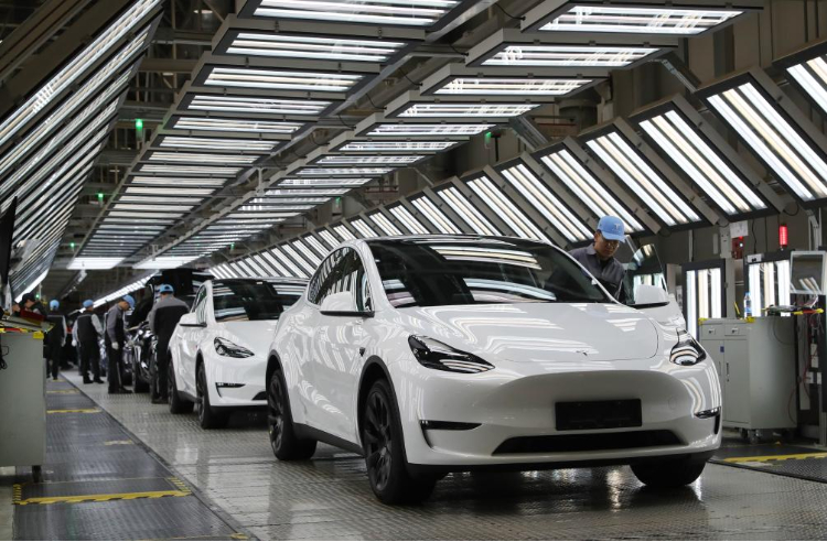 2023年12月22日，在特斯拉上海超級工廠內，工人在對出廠前的車輛進行漆面及門窗檢測。新華社記者 方喆 攝