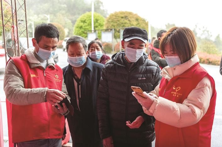 長沙縣黨員志愿者正在幫助參與核酸檢測的群眾掃描“場所碼”。劉思源 攝