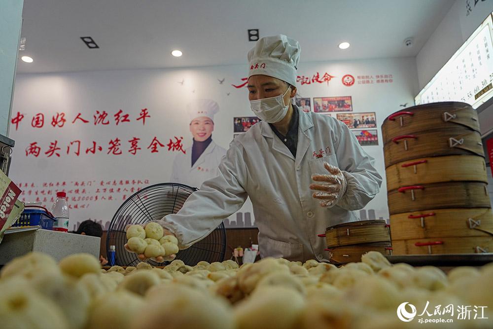 3月31日，在浙江省嵊州市甘霖鎮(zhèn)，嵊州小吃從業(yè)者沈紅平把蒸熟的小籠包晾涼，打包冷藏售賣。人民網(wǎng) 章勇濤攝