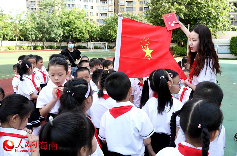 老師向少先隊員展示隊旗。人民網(wǎng) 符武平攝