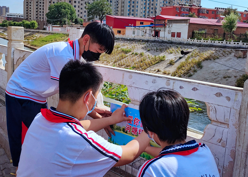 徐水小學(xué)學(xué)雷鋒志愿者在瀑河河邊張貼防溺水警示標(biāo)語。 徐水區(qū)委宣傳部供圖