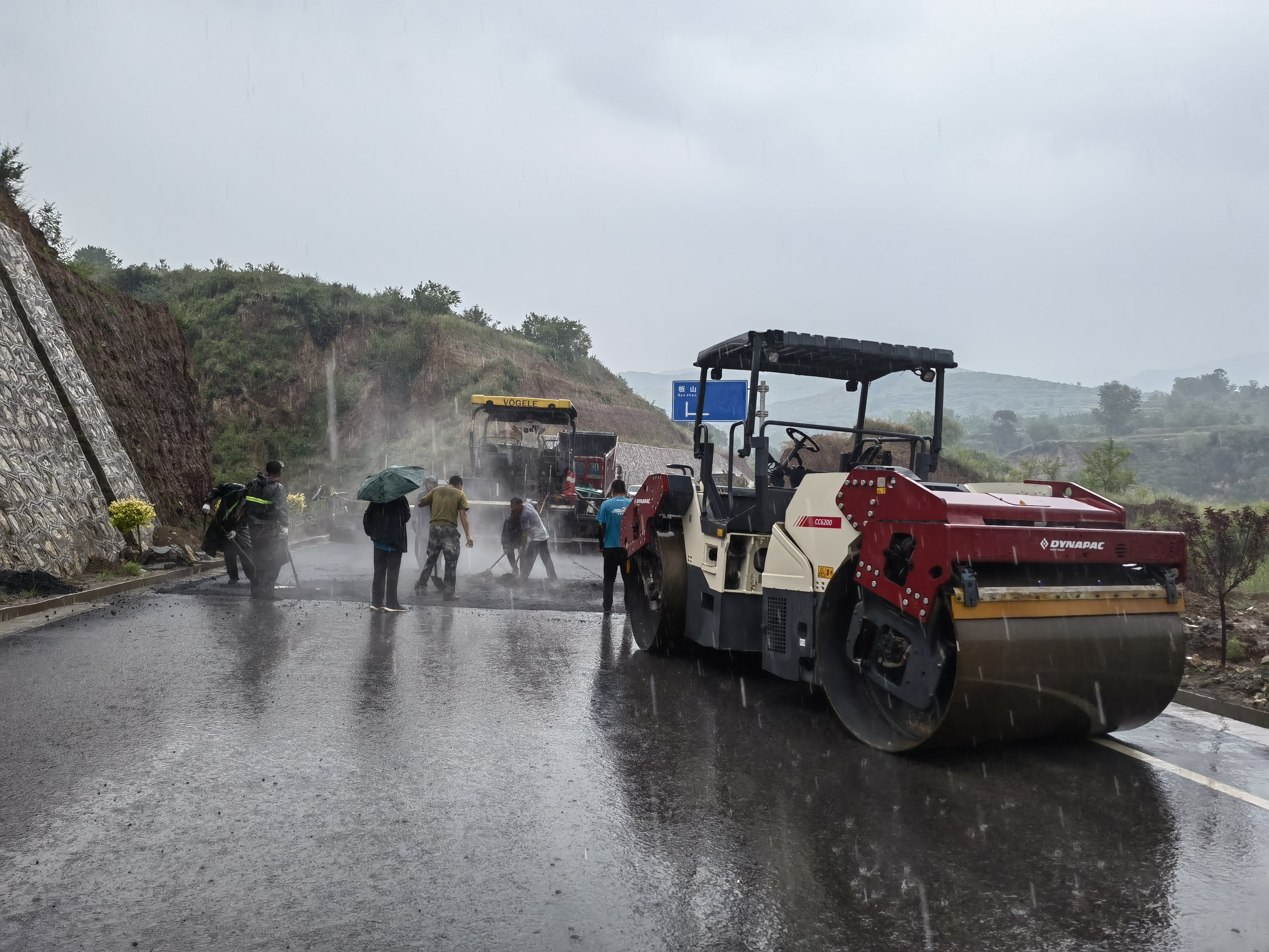 路橋工人在大雨中搶修道路。李華英 攝