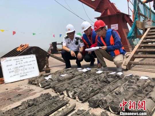 圖為勘察設(shè)計(jì)人員與海事局工作人員查看巖芯情況。　魏震 攝