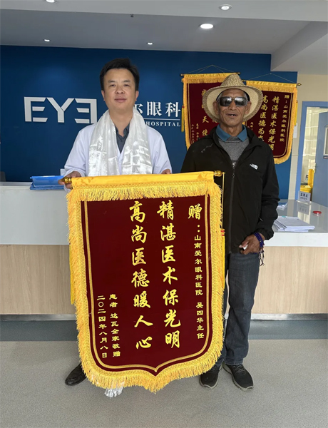 達(dá)瓦老人向吳四華（左）贈(zèng)送錦旗。受訪者供圖