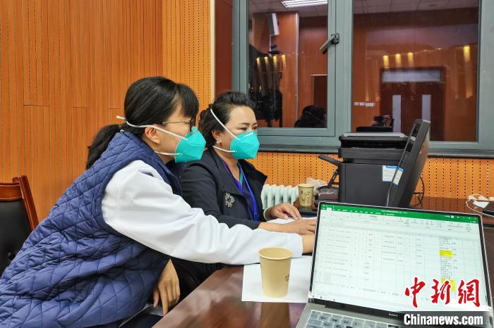 8月9日，楊蘇喬(左)在拉薩方艙醫(yī)院指揮部讀取艙內(nèi)患者胸部CT。　受訪者供圖