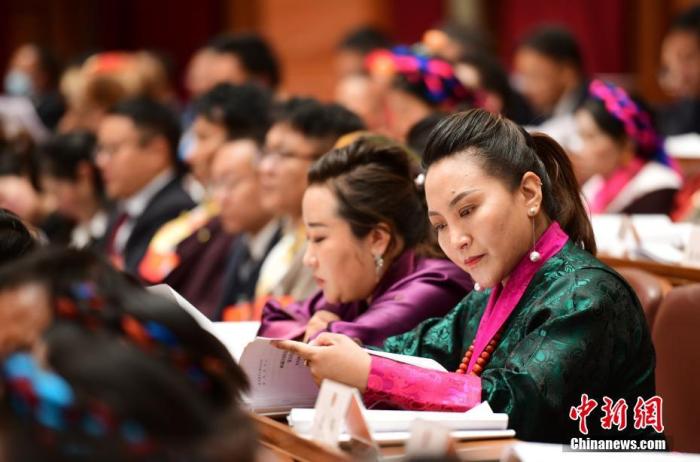 1月5日，次旦卓嘎(右一)在拉薩參加西藏自治區(qū)第十一屆人民代表大會第五次會議第二次全體會議。西藏自治區(qū)人大代表次旦卓嘎來自日喀則市定日縣，定日縣被稱為“洛諧故鄉(xiāng)”，作為西藏民間歌舞，洛諧已被列入中國國家非物質(zhì)文化遺產(chǎn)項(xiàng)目名錄，這是集歌、舞、樂、彈唱于一體的綜合藝術(shù)形式。參加完西藏2022年新年音樂會的次旦卓嘎告訴記者，每年參加的基層演出可達(dá)80場，“我希望用最純粹的方式，把最好的聲音帶到西藏乃至中國的各個角落。” <a target='_blank' href='/'><p  align=