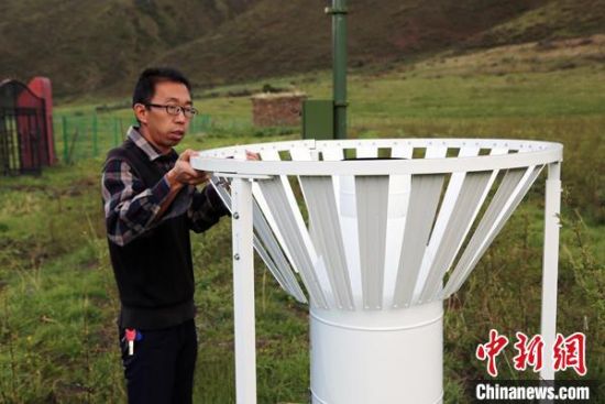 圖為班瑪縣氣象局工作人員在維護(hù)藏雪茶基地氣候站。青海省氣象局供圖