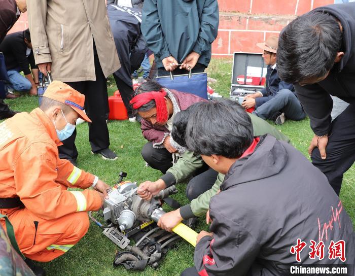 圖為森林消防員為護林員講解滅火裝備的使用方法?！〔际猩窒乐ш?供圖
