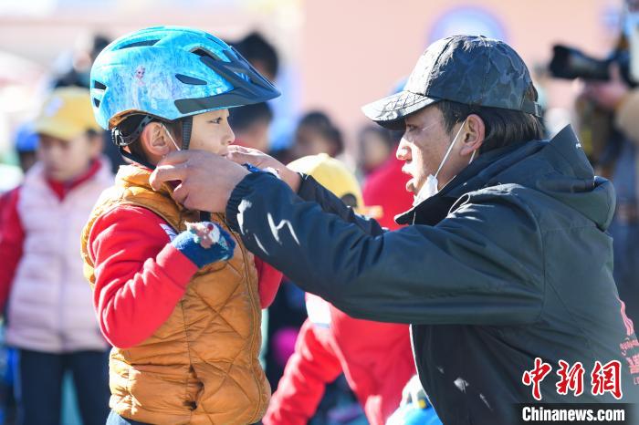 圖為拉薩市實驗幼兒園孩子在教練的幫助下穿戴頭盔?！『闻罾?攝