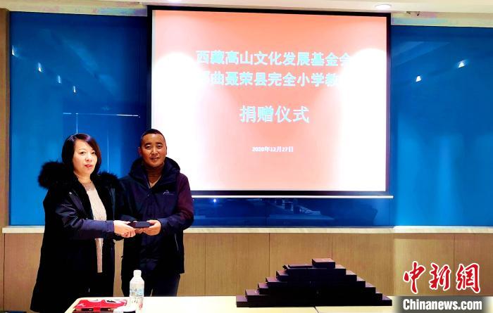 圖為西藏高山文化發(fā)展基金會理事長溫麗向聶榮縣完全小學(xué)負(fù)責(zé)人捐助儀器?！∮谫e 攝