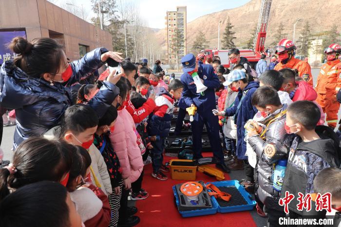 圖為小朋友們聽消防員講解消防器材。　楊龍建 攝