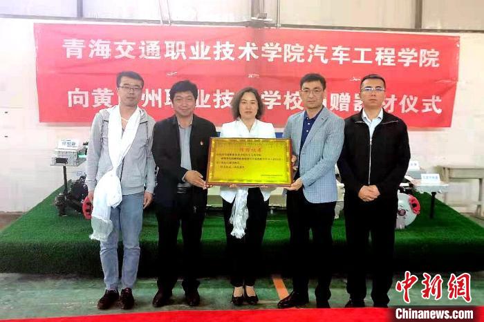 圖為李富香(中)代表學(xué)校為州縣技校捐贈器材。(資料圖) 青海省教育廳供圖