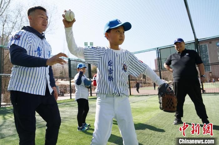 圖為教練指導(dǎo)小棒球手?jǐn)S球技術(shù)?！●R銘言 攝