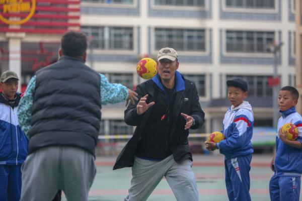 在高原上教孩子們打手球，“慢慢兒來，甭著急！”