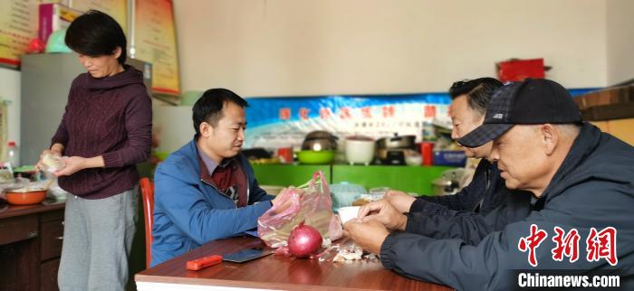 圖為扶貧路上“臨時(shí)一家人”準(zhǔn)備午餐?！∥航ㄜ?攝