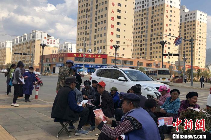 圖為會(huì)澤縣城易地扶貧搬遷安置點(diǎn)內(nèi)，老人們聚在廣場(chǎng)上聊天，身后是他們的新家?！】姵?攝