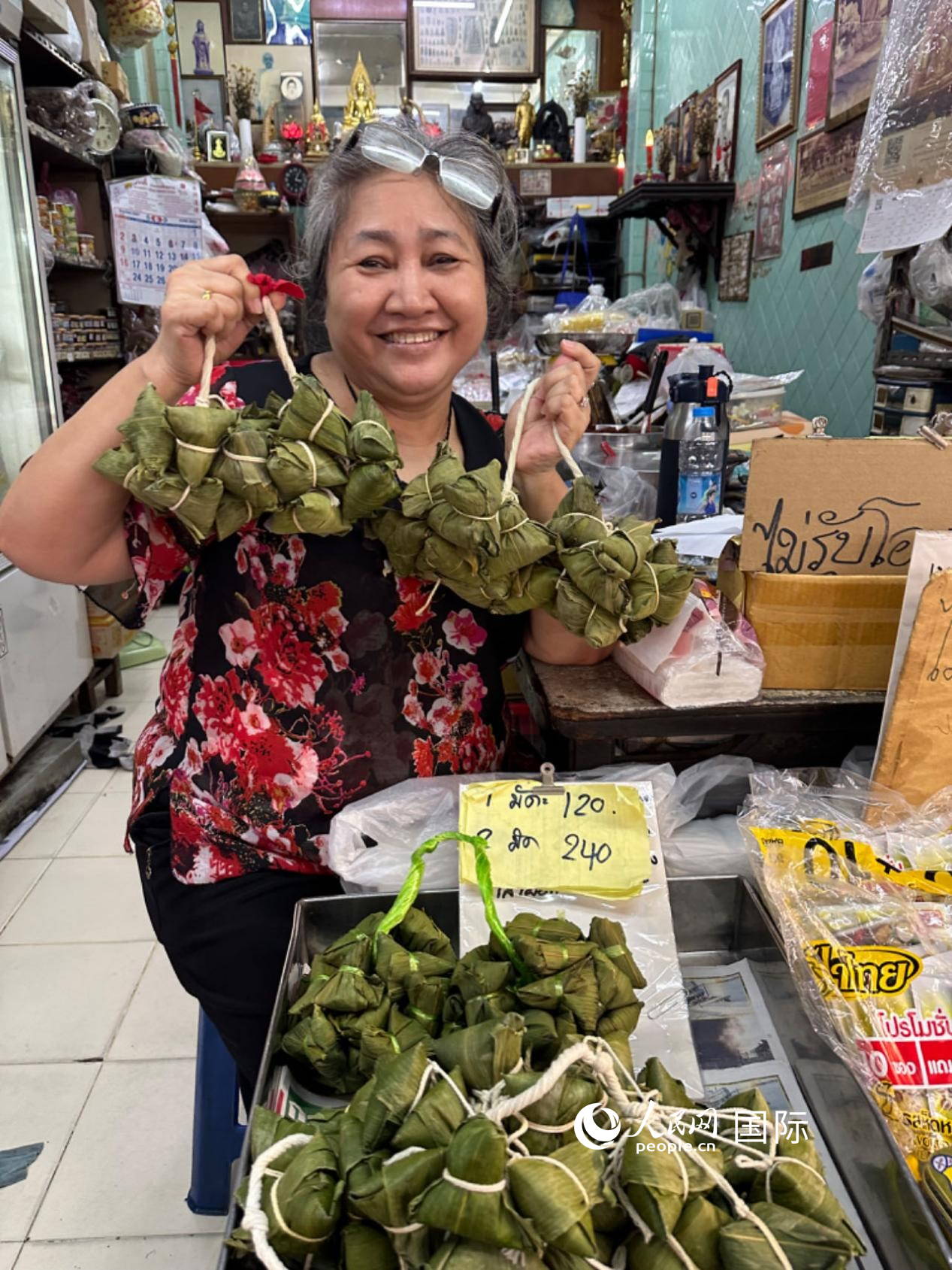 商家向顧客介紹“吉掌”（粽子的一種，一串一串，個(gè)頭較小）。人民網(wǎng)記者 簡承淵攝