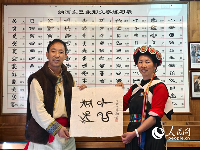 人民網(wǎng)“行進(jìn)中國(guó)”云南調(diào)研采訪(fǎng)團(tuán)走進(jìn)麗江，和閏元現(xiàn)場(chǎng)用東巴文寫(xiě)下“行進(jìn)中國(guó)”。人民網(wǎng)記者 符皓攝