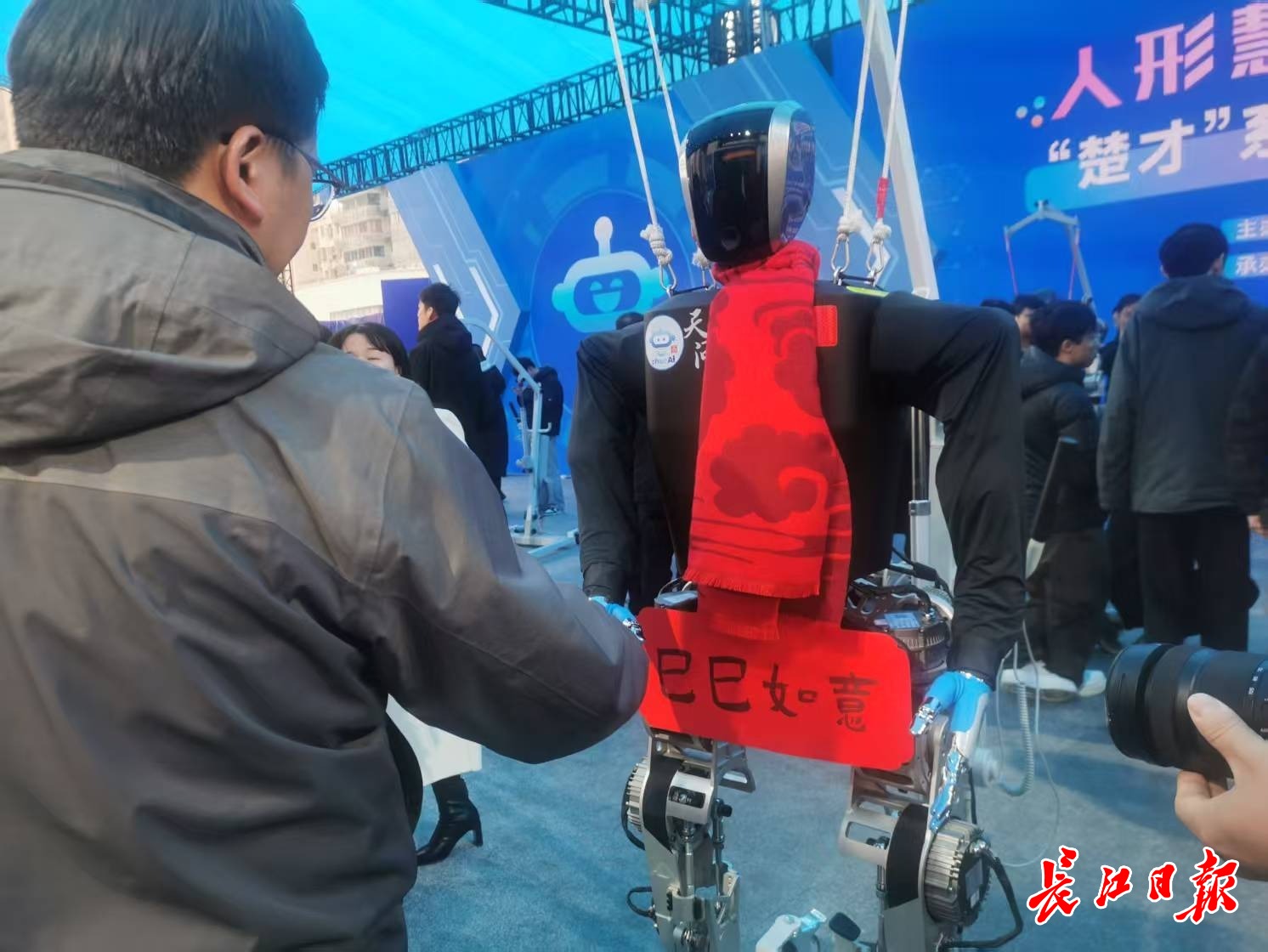 “天問”人形機(jī)器人和參觀市民握手，互致新年快樂。 長江日報記者陳永權(quán) 攝
