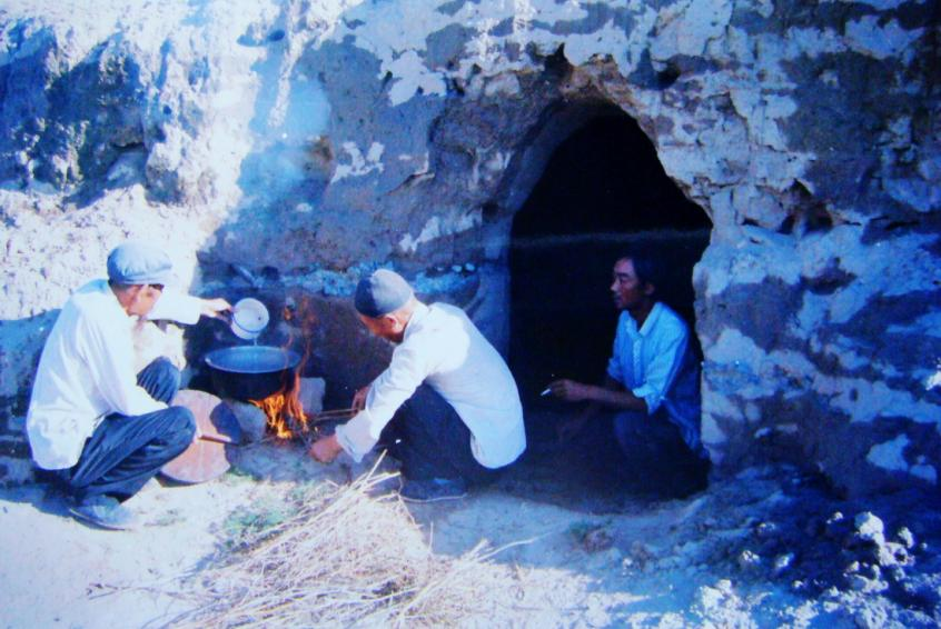 1983年，“六老漢”一代治沙人在“地窩子”生活做飯。新華社發(fā)（八步沙林場供圖）