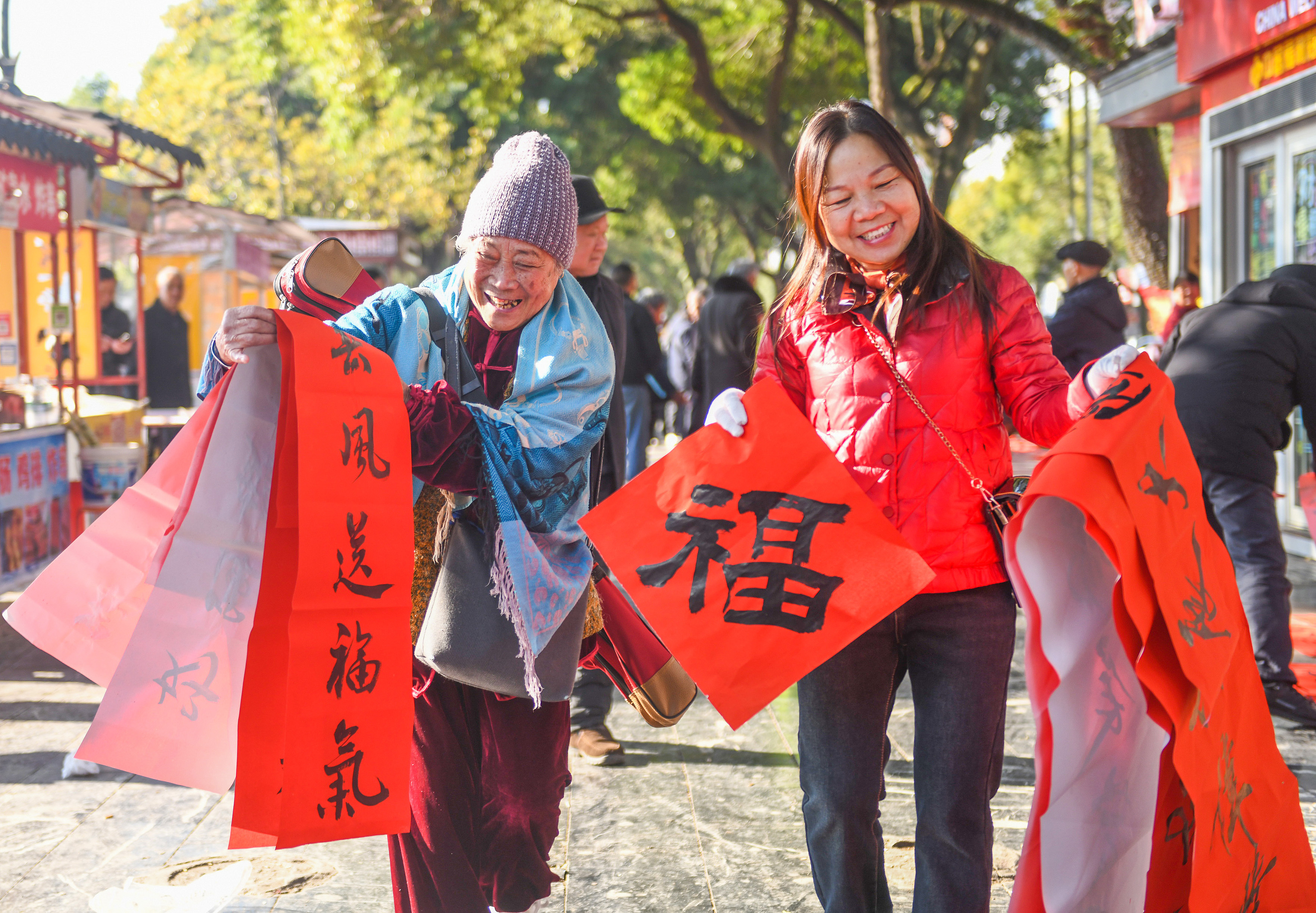 2025年1月13日，在湖南省永州市道縣西洲公園義工崗亭，市民們領到了書法志愿者為大家書寫的春聯(lián)。