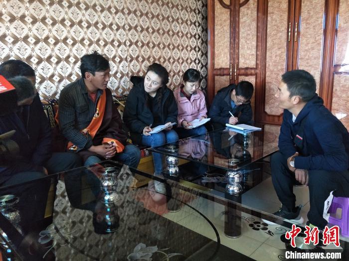 圖為調(diào)查組工作人員正在入戶調(diào)查?！∑钤鲚?攝