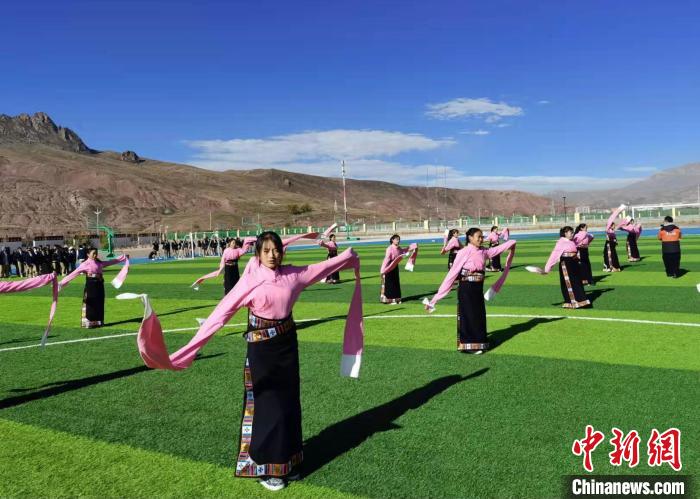 圖為青海師范大學(xué)附屬玉樹實驗學(xué)校學(xué)生在綠茵場跳起囊謙古舞—卓根瑪?！“讋?攝