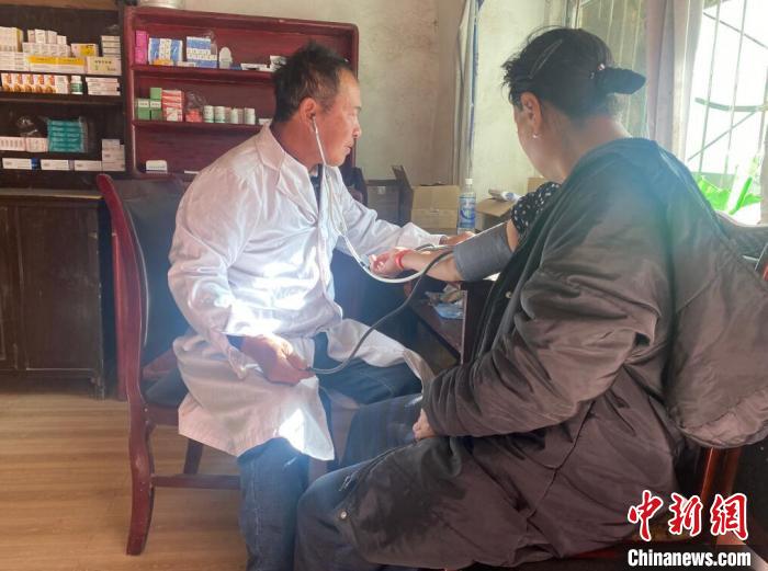 索木滾(左)為村民看病?！∪捞量h委宣傳部供圖